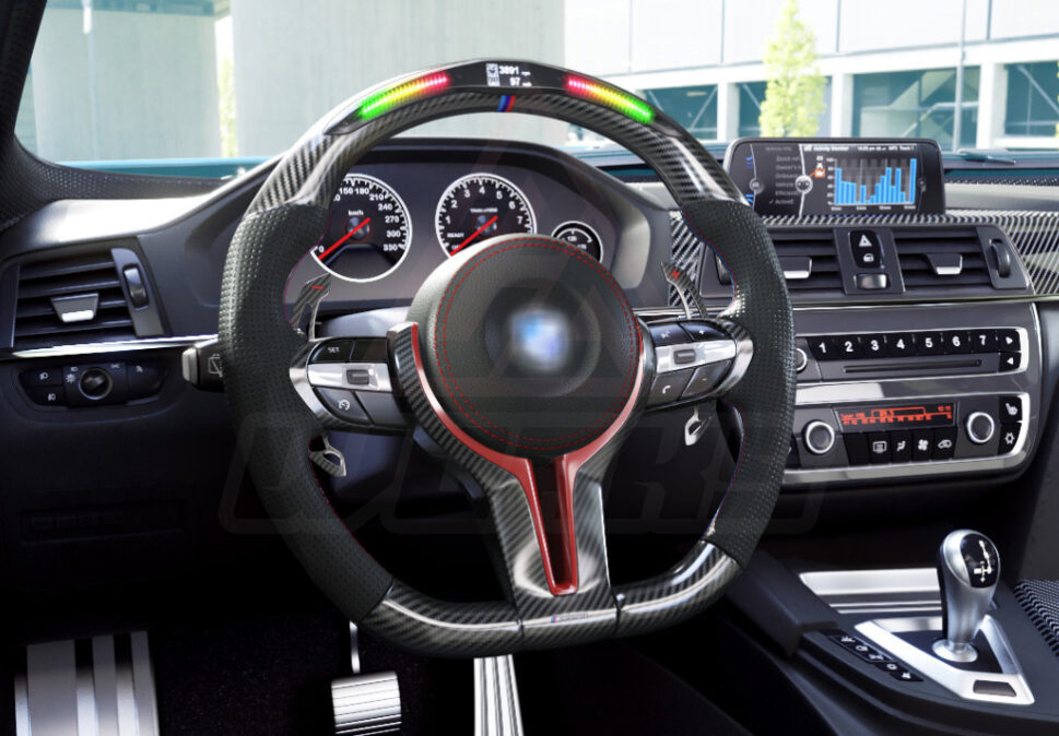 Side view of a BMW F chassis, M sport steering wheel in carbon fiber, hollow design paddle shifters, a mix of red and M color accents, black perforated leather and led shift lights